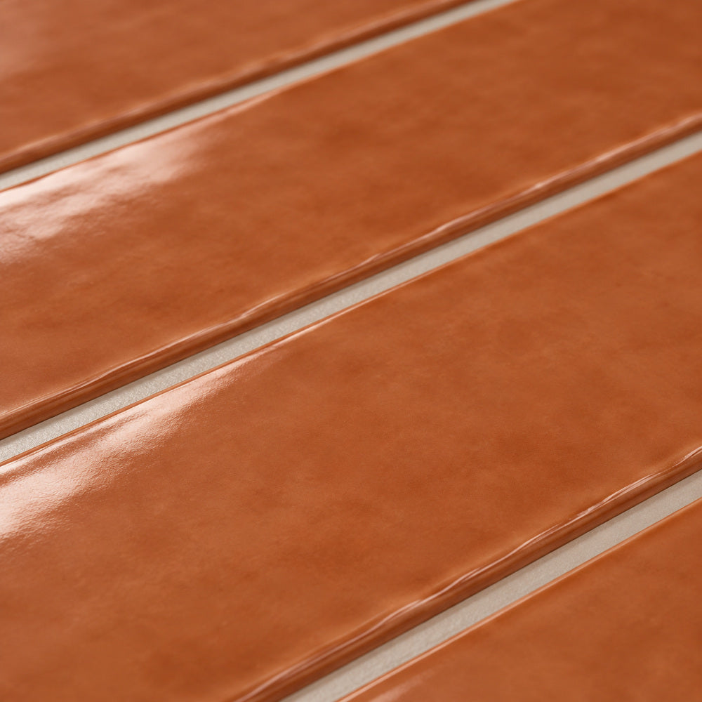 Ambrya copper 2x20 glossy ceramic tile — angled glaze detail