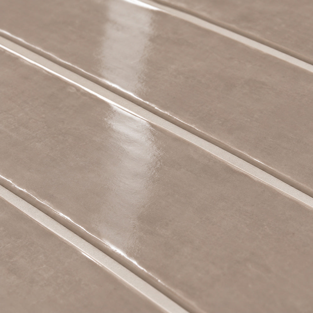 Ambrya sandstone 2x20 glossy ceramic tile — angled glaze detail