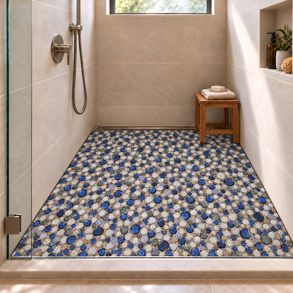 Nevis Pearl Blue Pebble Mosaic installed on a shower floor, small irregular reactive-glaze mosaic chips